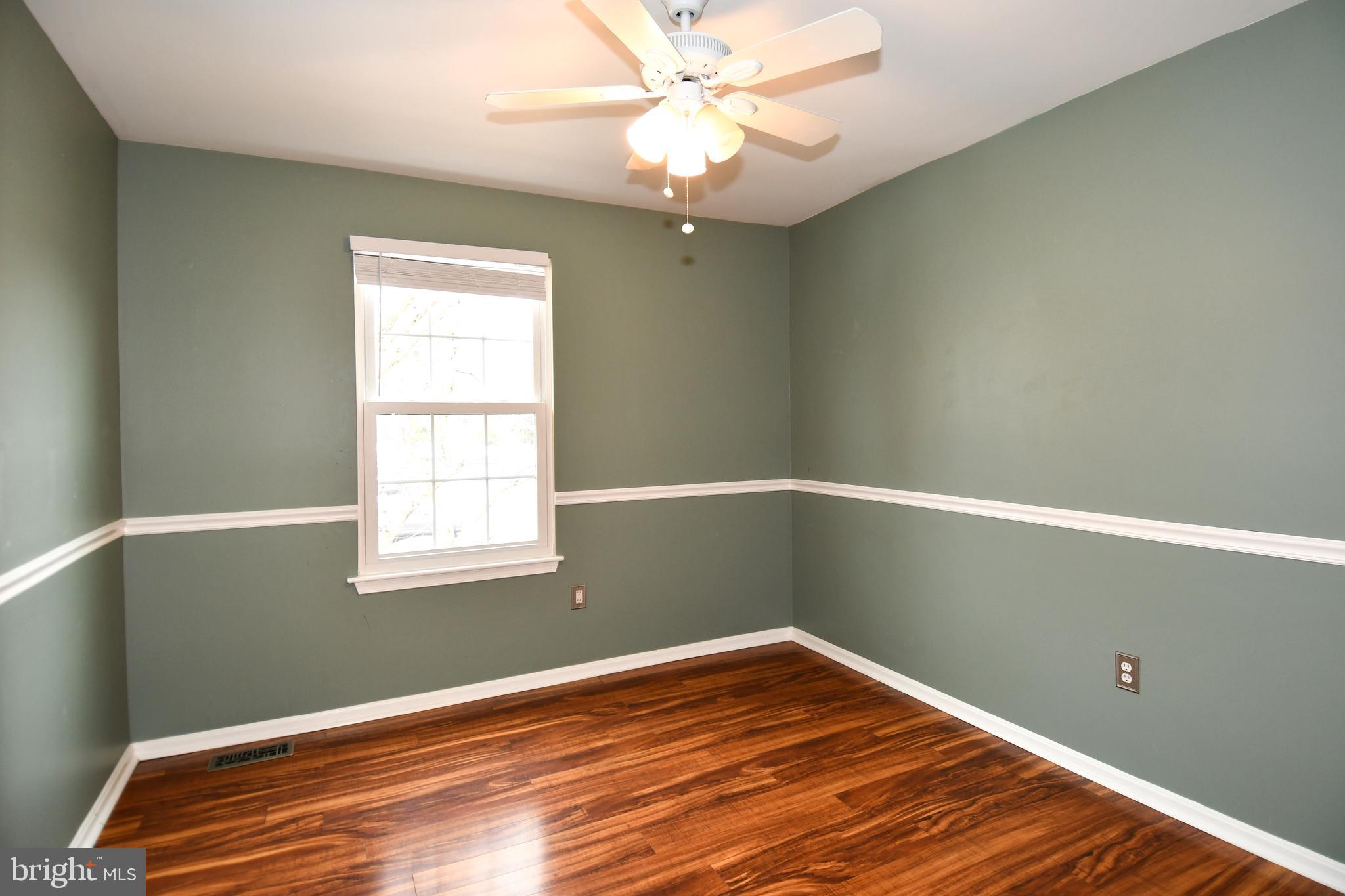 11796 Lone Tree Court Columbia, MD 21044 - Photo 22 of 45 a view of an empty room with wooden floor and a window