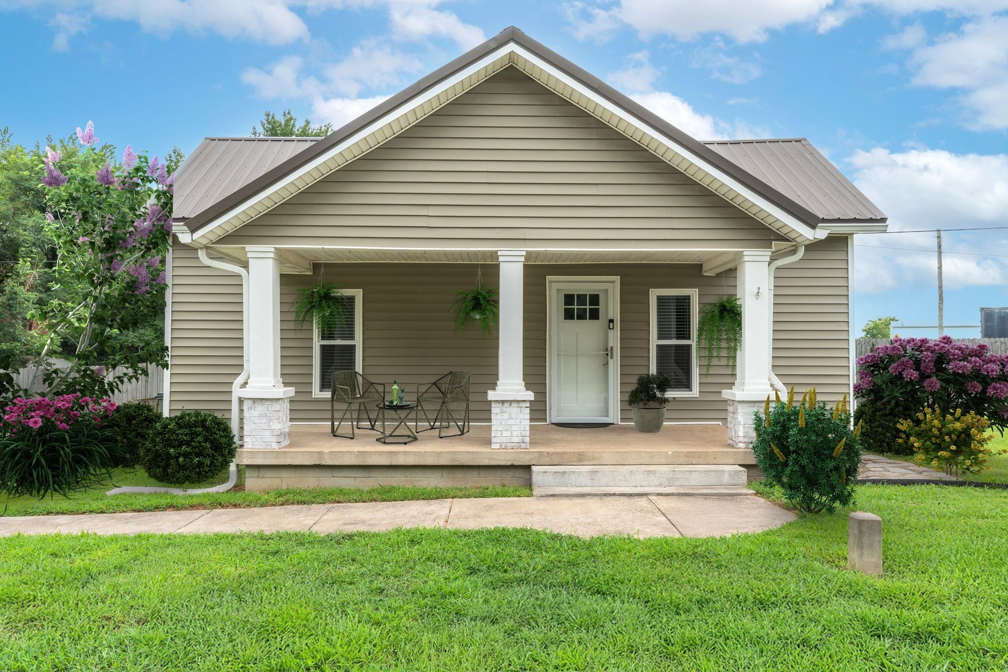 a front view of a house with a garden and plants