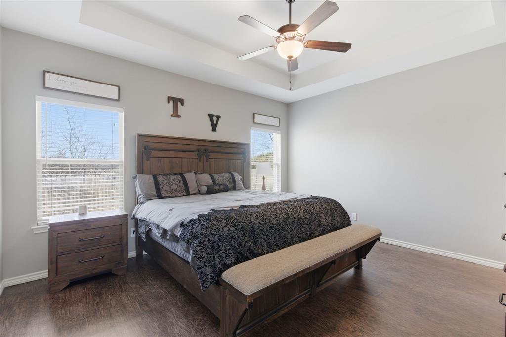 711 Hadley Lane Valley View, TX 76272 - Photo 15 of 40 Bedroom featuring a tray ceiling, dark wood-style flooring, and ceiling fan