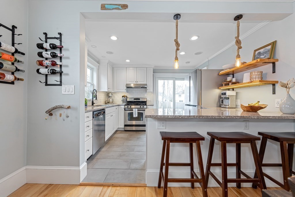6 Storey Avenue Newburyport, MA 01950 - Photo 11 of 41 a kitchen with stainless steel appliances granite countertop a table chairs in it and wooden floors