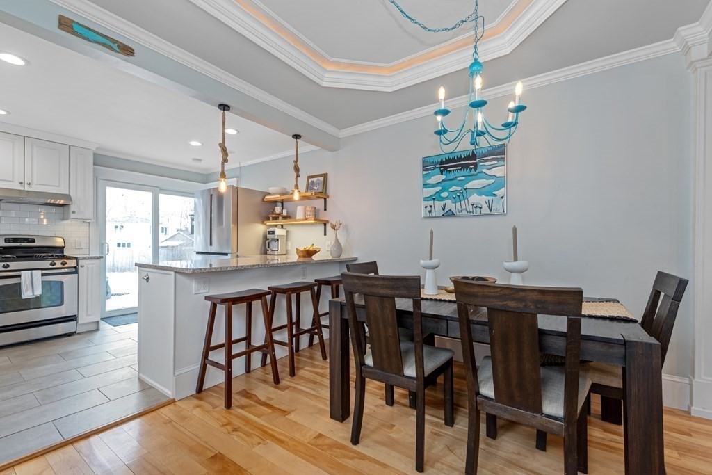 6 Storey Avenue Newburyport, MA 01950 - Photo 18 of 41 a dining room with furniture a chandelier and wooden floor