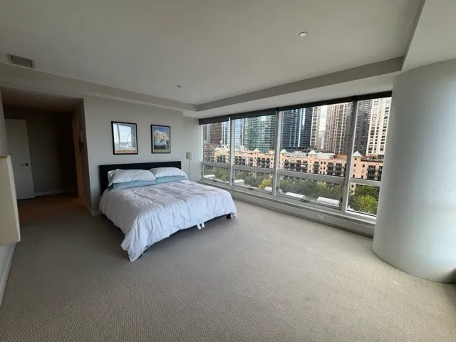 a bedroom with a bed and a large window
