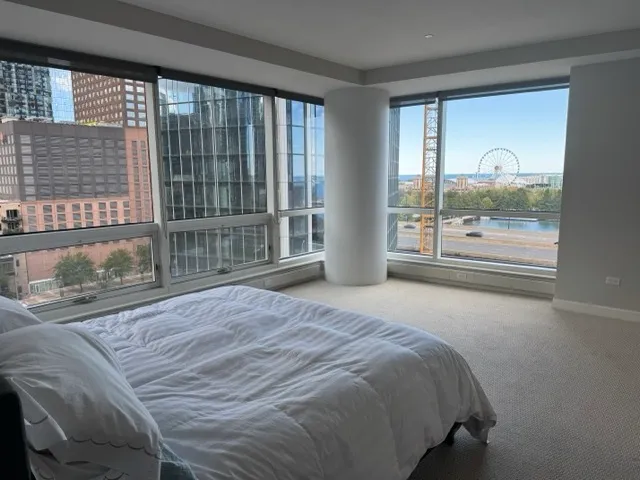 a bedroom with a bed and a large window