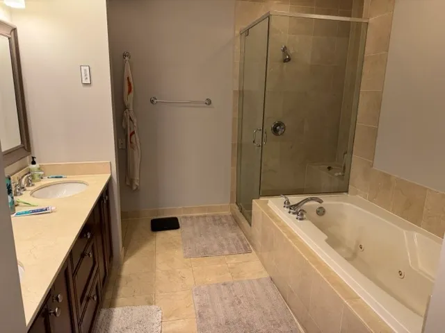 a bathroom with a tub sink a mirror and shower