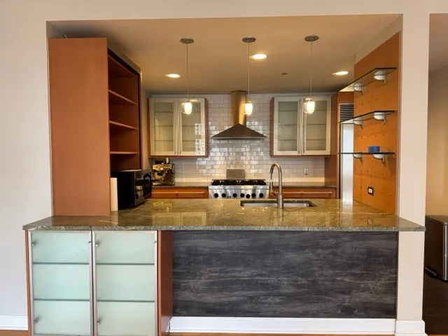 a view of kitchen with stainless steel appliances granite countertop sink and cabinets