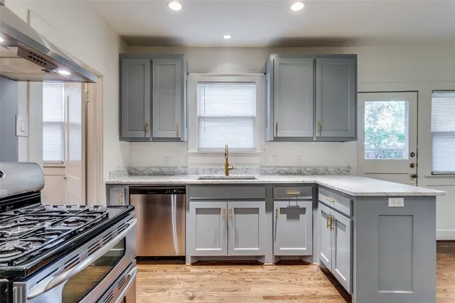 a kitchen with granite countertop a sink stove and cabinets