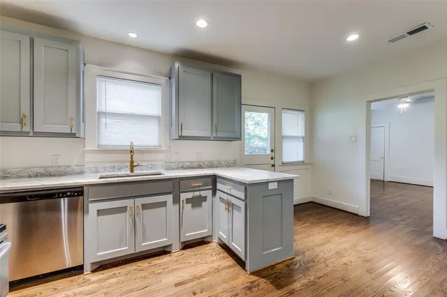 a kitchen with a sink cabinets and wooden floor