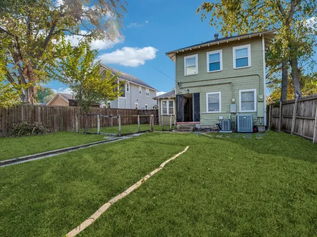a view of a house with a big yard and large trees