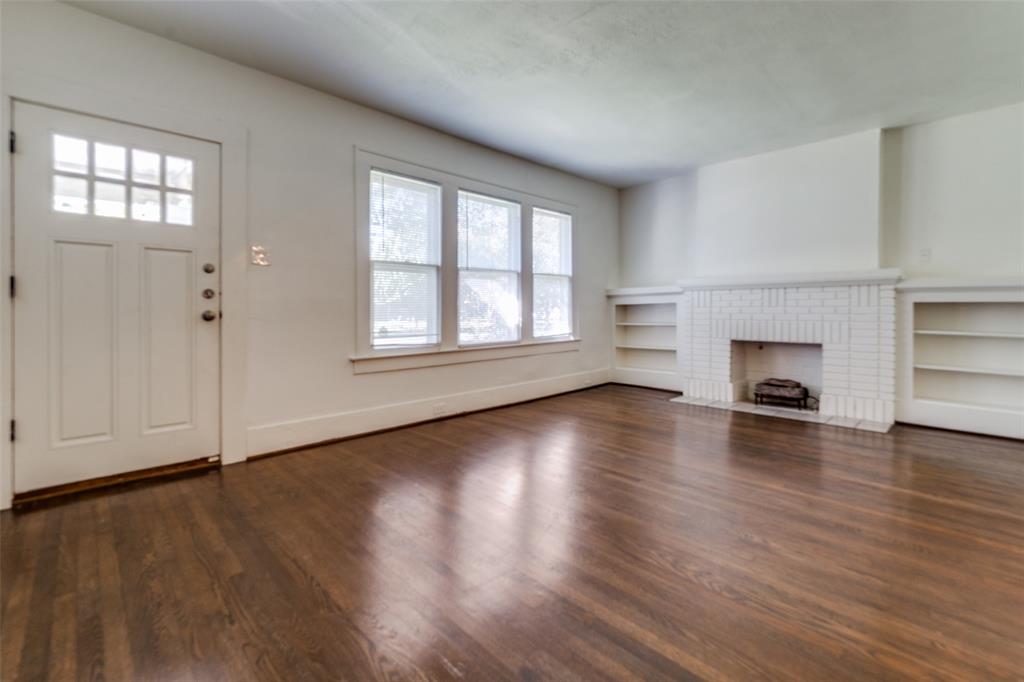 732 North Windomere Avenue Dallas, TX 75208 - Photo 4 of 33 an empty room with wooden floor fireplace and windows