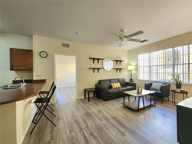 a kitchen with stainless steel appliances granite countertop a refrigerator a stove and a sink with wooden floor