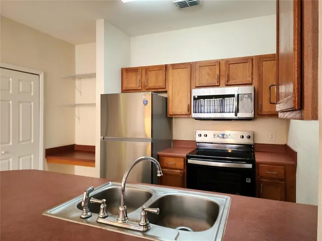 a kitchen with a refrigerator and a stove