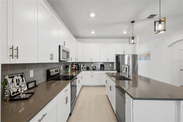 a kitchen with stainless steel appliances granite countertop a sink refrigerator and cabinets