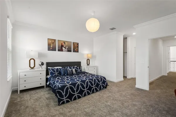 a bedroom with a bed and painting on the wall