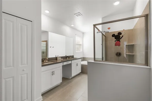 a large white kitchen with stainless steel appliances a refrigerator and a sink