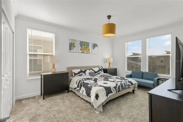 a bedroom with a bed a couch and a window