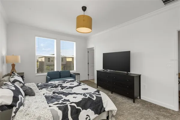a bedroom with a bed and a flat screen tv