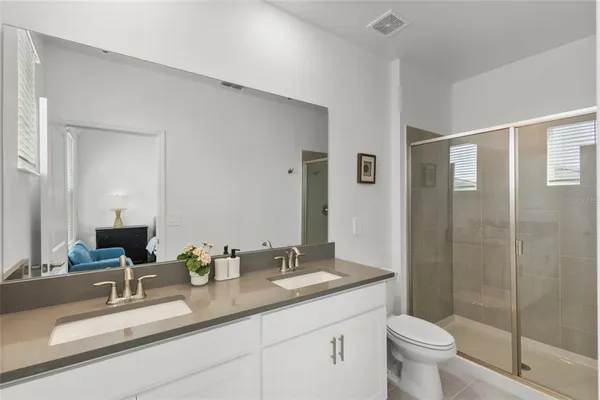 a bathroom with a double vanity sink toilet and shower