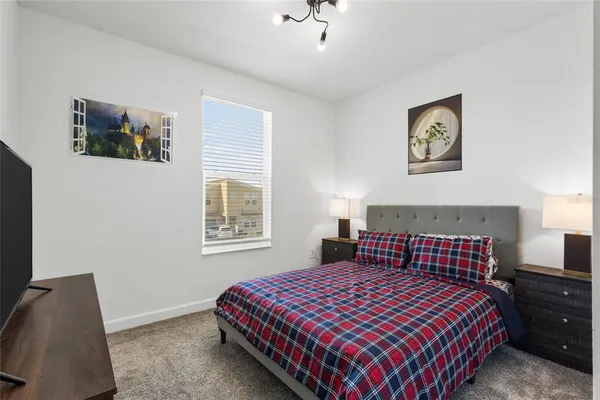 a bedroom with a bed and a lamp on dresser