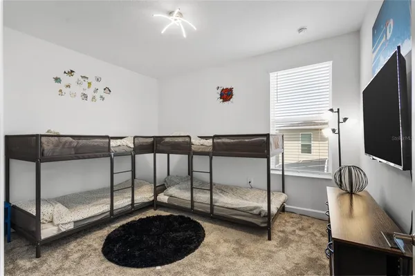 a bedroom with a bed and a flat tv screen on the wall