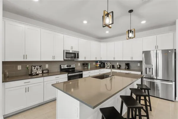 a kitchen with granite countertop a sink stainless steel appliances and white cabinets