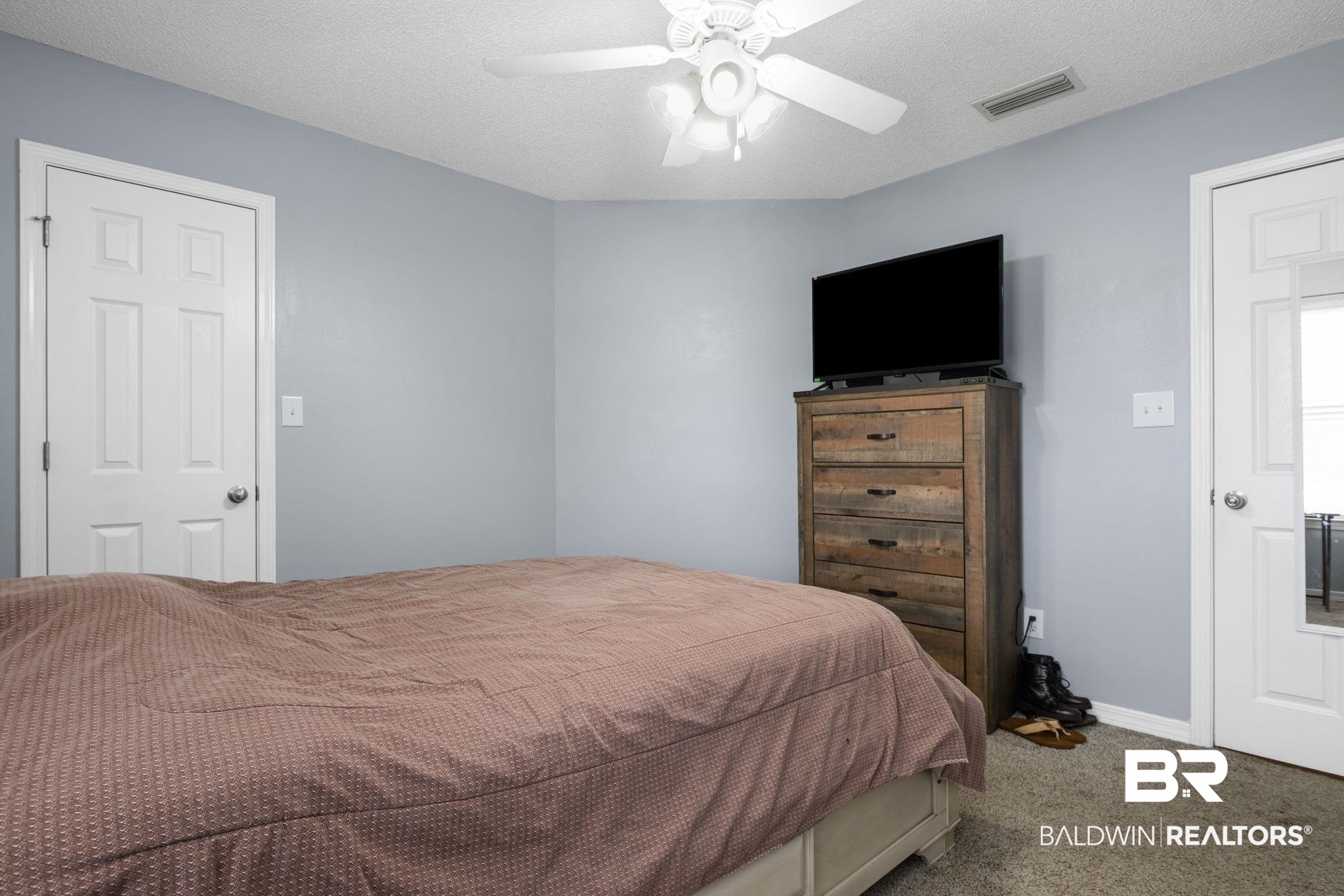 9422 Labrador Run South Mobile, AL 36695 - Photo 25 of 36 Interior room featuring light blue walls, a white ceiling fan with integrated lighting, and neutral carpet flooring