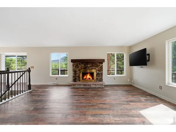 a view of a livingroom with a fireplace a flat screen tv and staircase