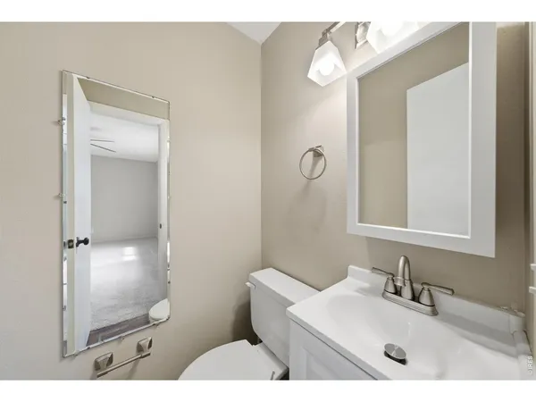 a bathroom with a granite countertop sink mirror and toilet