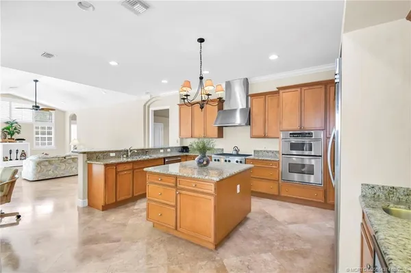 a kitchen with stainless steel appliances granite countertop a sink a stove and a refrigerator