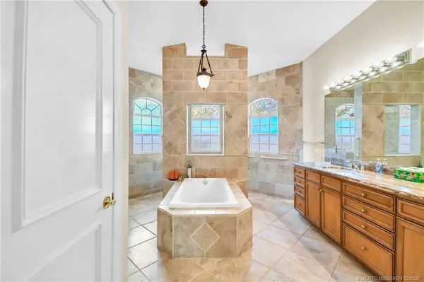 a spacious bathroom with a granite countertop sink and a mirror