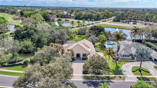 an aerial view of a house with a garden and lake view