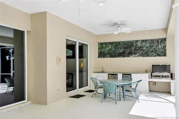 a view of a backyard with chair and potted plants