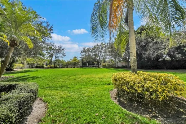 a view of a big house with a big yard and large trees