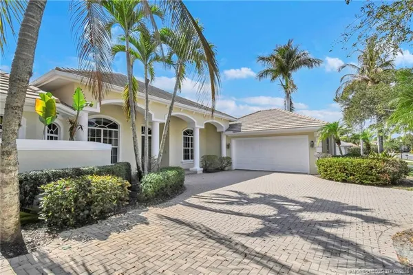 a front view of a house with a yard and potted plants