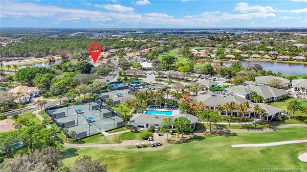 an aerial view of a residential houses with outdoor space and trees
