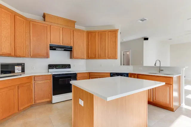 a kitchen with stainless steel appliances a stove a sink and a refrigerator