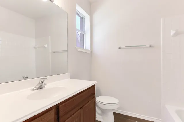 a bathroom with a sink a toilet and a mirror