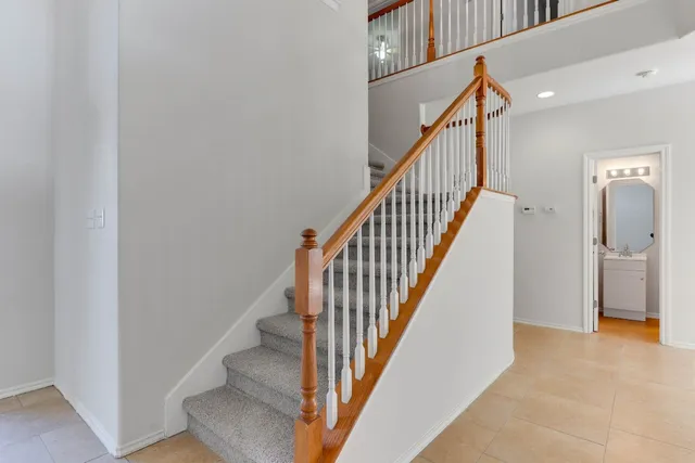 a view of staircase with lots of frames on wall and wooden floor