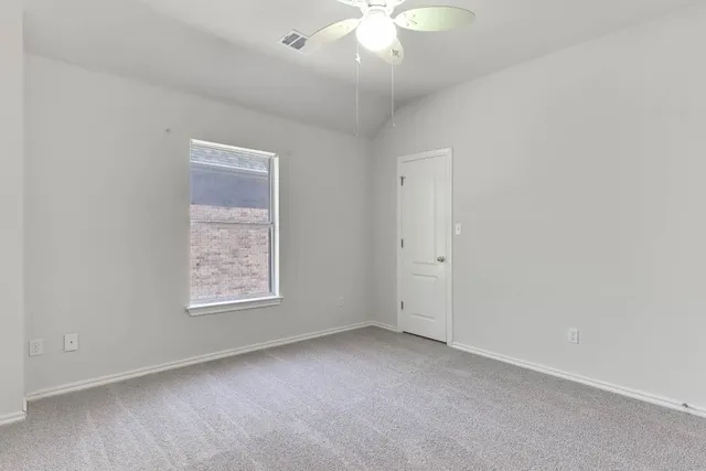 an empty room with a chandelier fan
