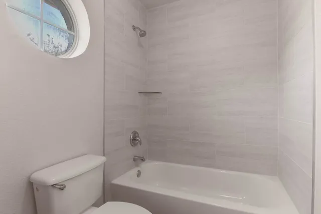 a white bath tub sitting next to a toilet