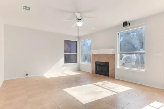 an empty room with windows and fireplace