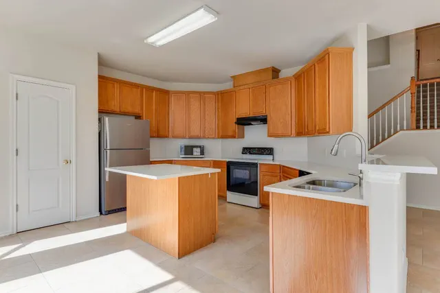 a kitchen with stainless steel appliances granite countertop a refrigerator sink stove and large window