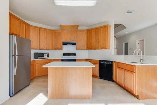 a kitchen with stainless steel appliances granite countertop a stove a refrigerator a sink and dishwasher