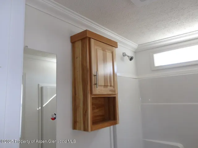 a bathroom with a glass door shower and a sink