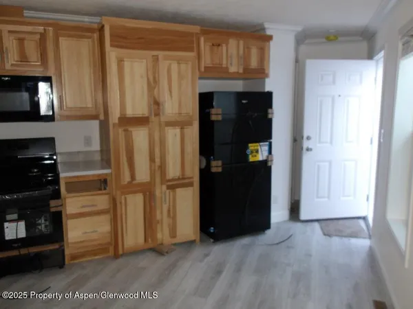 a view of kitchen with refrigerator cabinets and a window