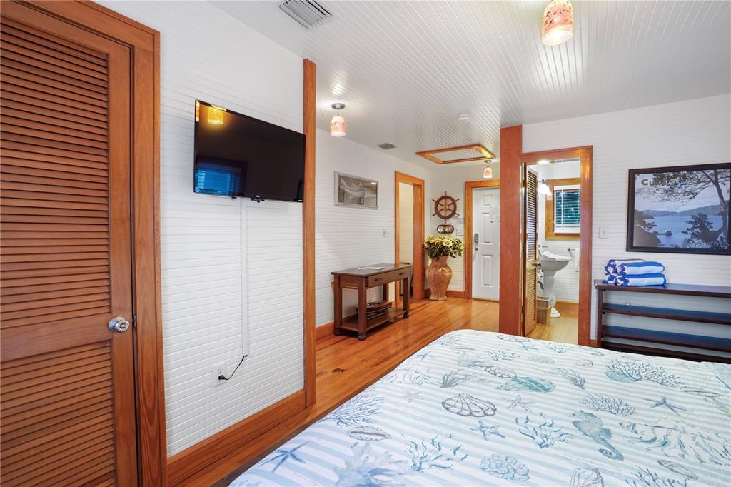 702 Pass A Grille Way St. Pete Beach, FL 33706 - Photo 22 of 41 a bedroom with furniture and a flat screen tv