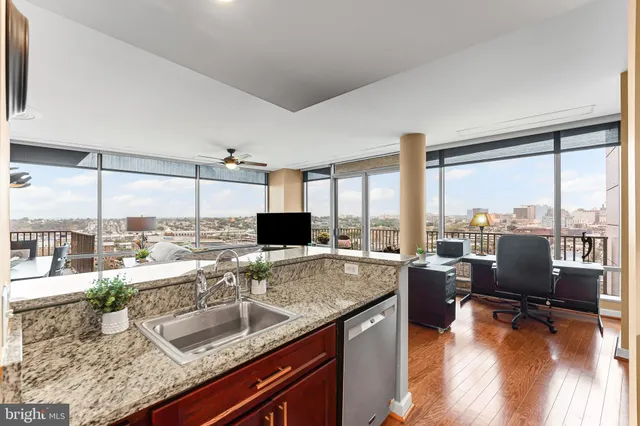 a kitchen with kitchen island granite countertop wooden floors and stainless steel appliances