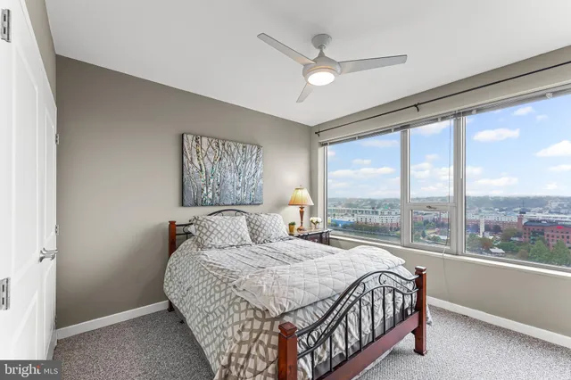 a bathroom with a toilet a sink a mirror a window and vanity
