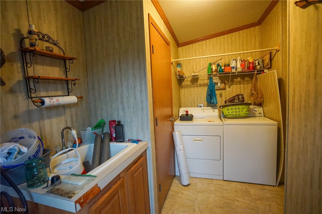 37632 Sheepskin Ridge Road Lower Salem, OH 45745 - Photo 8 of 30 Clothes washing area with sink, crown molding, light tile flooring, separate washer and dryer, and cabinets