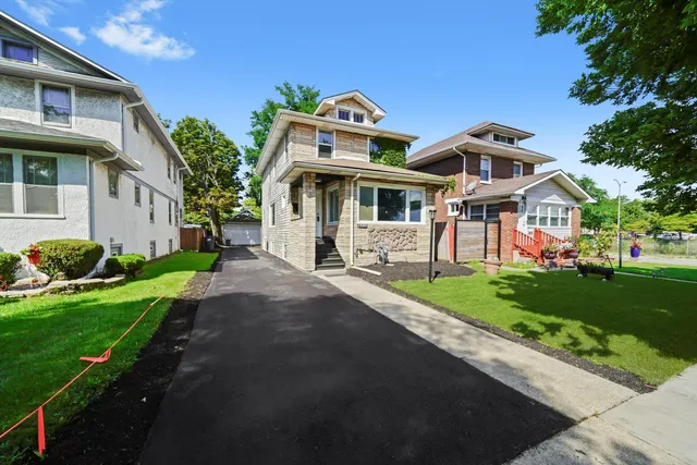a front view of a house with a garden and trees