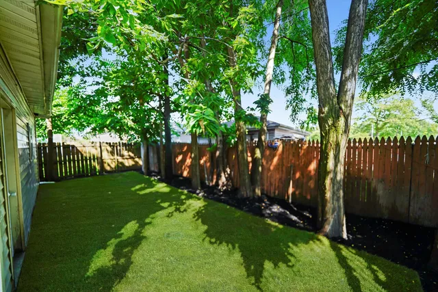 a view of yard with green space and wooden fence